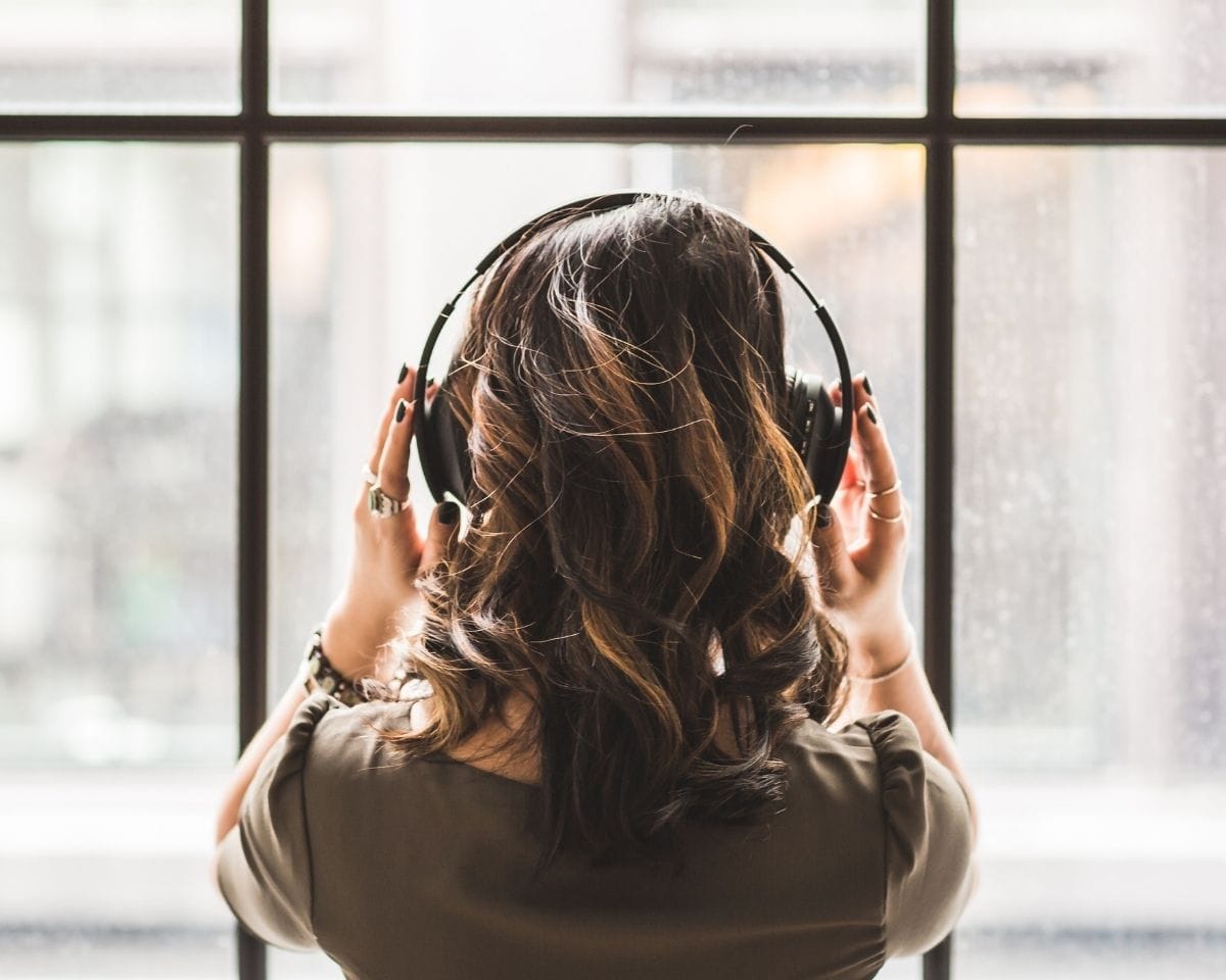 Woman with headphones on listening to podcast