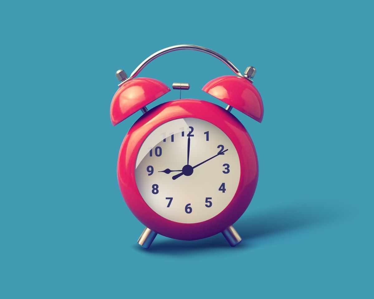 Red alarm clock on a blue background