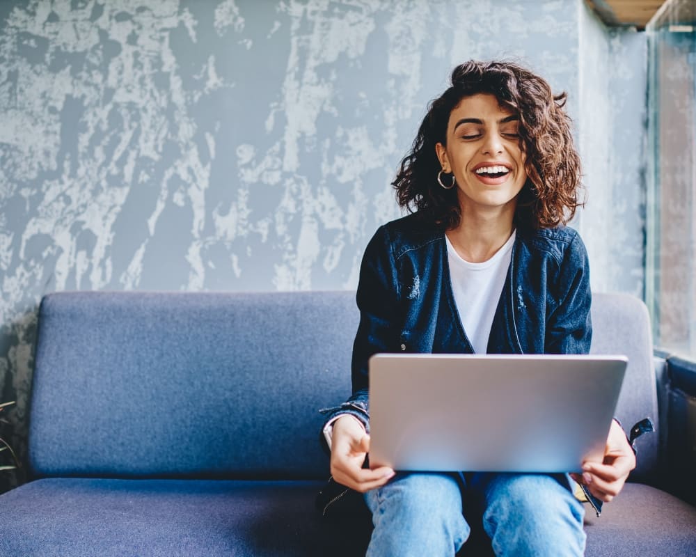 Female podcaster with laptop sitting on couch